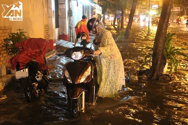 
Nhiều người dân phải dắt xe khó khăn di chuyển trong dòng nước